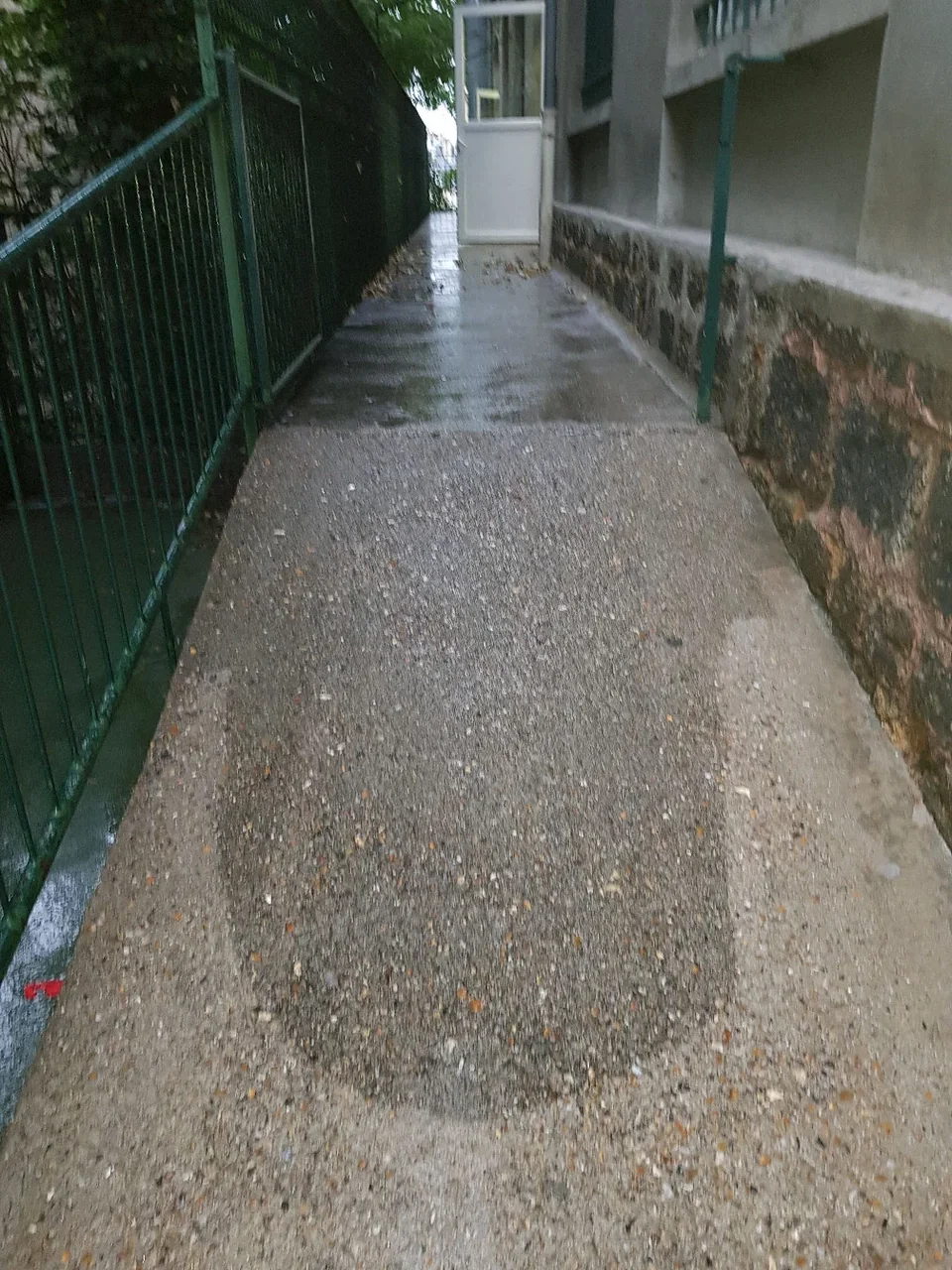 Allée extérieure entre un bâtiment et une clôture