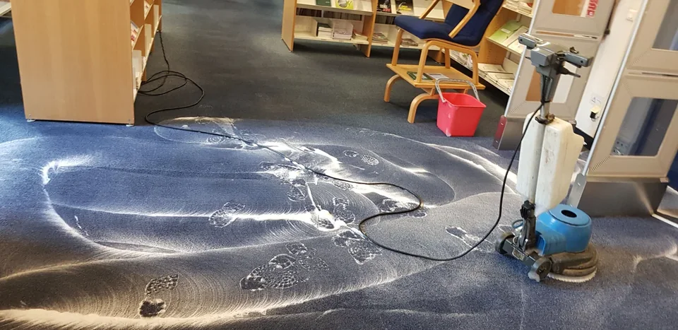 Monobrosse et mousse sur la moquette devant des étagères